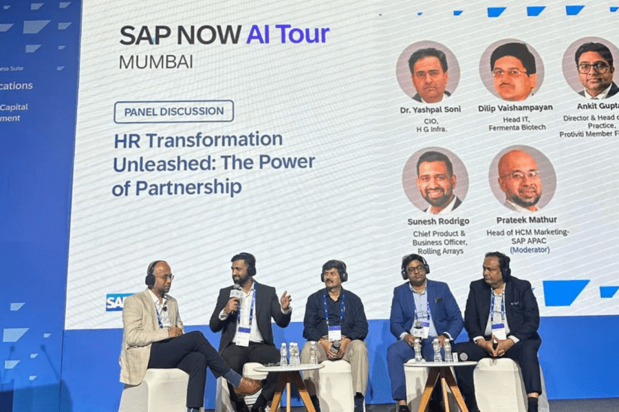 A panel discussion on "HR Transformation Unleashed: The Power of Partnership" at the SAP NOW AI Tour in Mumbai. The image shows five men seated on a stage, with a large screen behind them displaying the event title and the names of the panelists, including Sunesh Rodrigo from Rolling Arrays and Prateek Mathur from SAP.